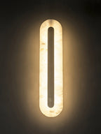 Alabaster wall sconce detail with brass trim and soft lighting