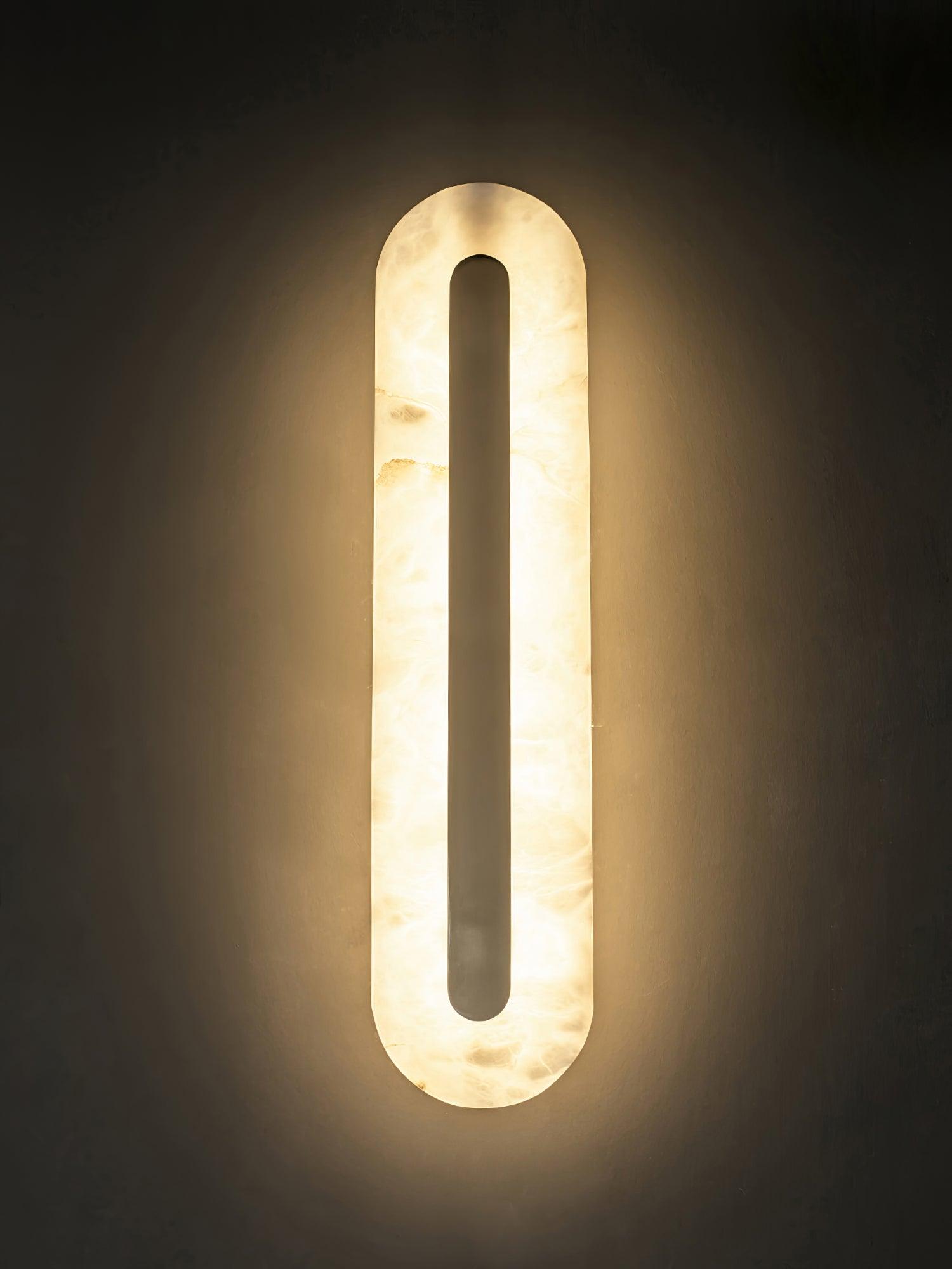 Alabaster wall sconce detail with brass trim and soft lighting