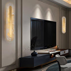 Two Clérachic Selvia wall lights lit either side of a wall-mounted television in a panelled living room