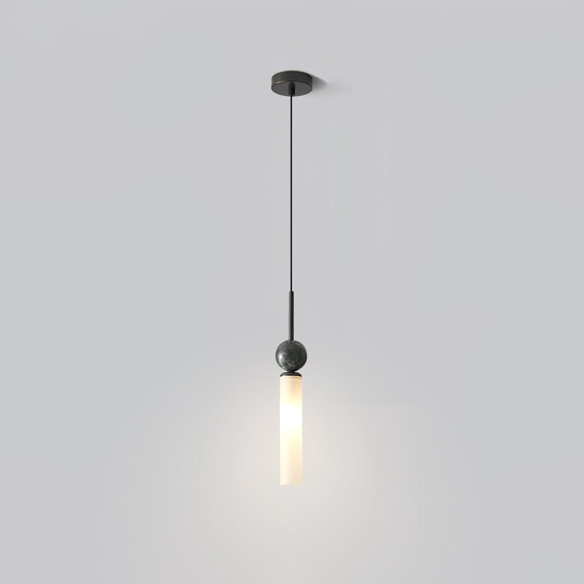 A studio shot of a single black marble Clérachic pendant light on a plain grey background, showing its straight ceiling stem.