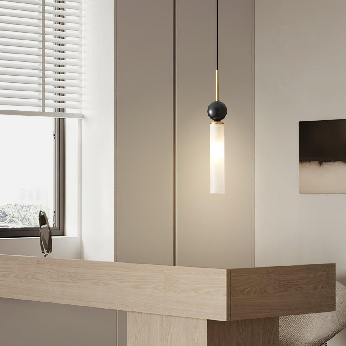 A close-up of a single black marble Clérachic pendant light beside a window with blinds, framed wider than the matching shot.