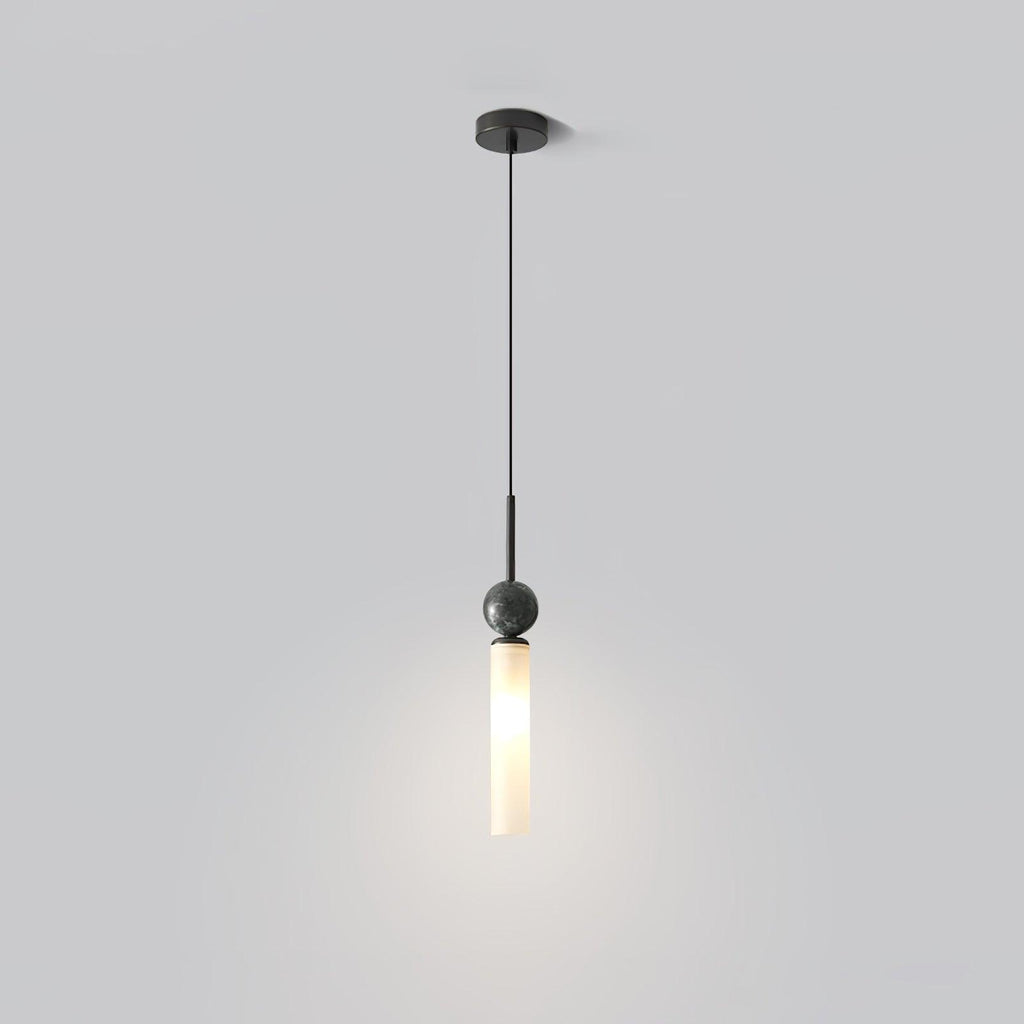 A single Clérachic pendant drops from a round black ceiling canopy, its frosted glass cylinder glowing against a soft grey backdrop.