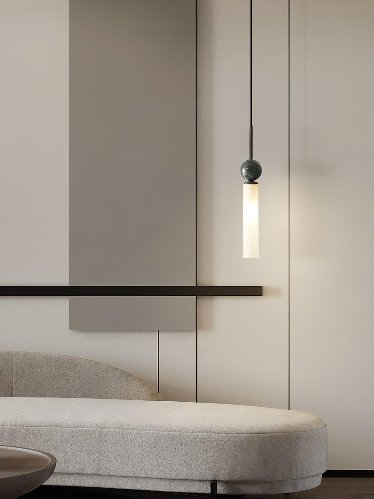 A close-up of a single black marble Clérachic pendant light beside a slim wall bar and bench, on a plain taupe wall.