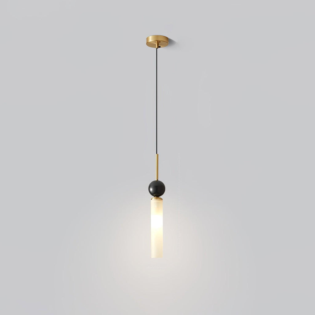 A studio shot of a single Clérachic pendant light on a plain background, showing its brass canopy, marble ball and frosted shade.