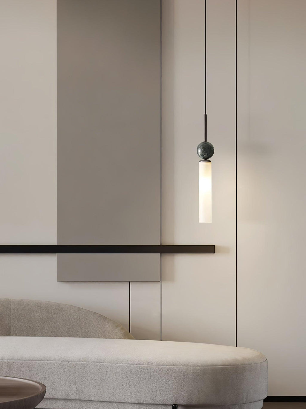 A close-up of a single black marble Clérachic pendant light beside a slim wall bar, cropped tighter than the matching shot.
