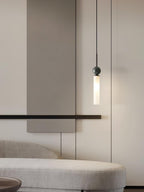 A close-up of a single black marble Clérachic pendant light beside a slim wall bar, cropped tighter than the matching shot.