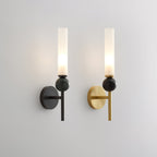 A pair of Clérachic wall sconces on grey, black arm beside brass arm, comparing the marble orb and frosted shade across finishes.