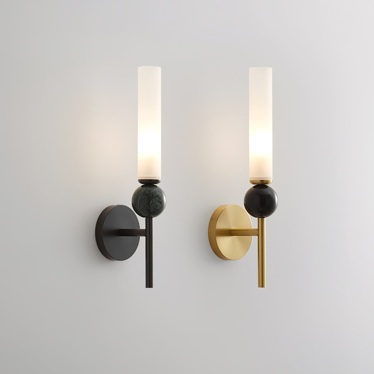 A pair of Clérachic wall sconces on grey, black arm beside brass arm, comparing the marble orb and frosted shade across finishes.
