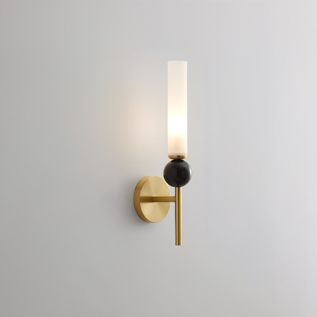 Front-facing against grey, this Clérachic brass-arm wall sconce presents a black marble orb in studio light.