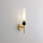 Front-facing against grey, this Clérachic brass-arm wall sconce presents a black marble orb in studio light.