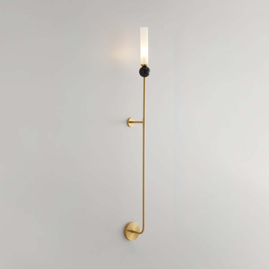 Shown at an angle, full length, this tall Clérachic brass vertical wall light stands against a plain grey background.
