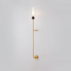 Seen from a slightly different angle, this tall Clérachic brass vertical wall light stands full length on plain grey.