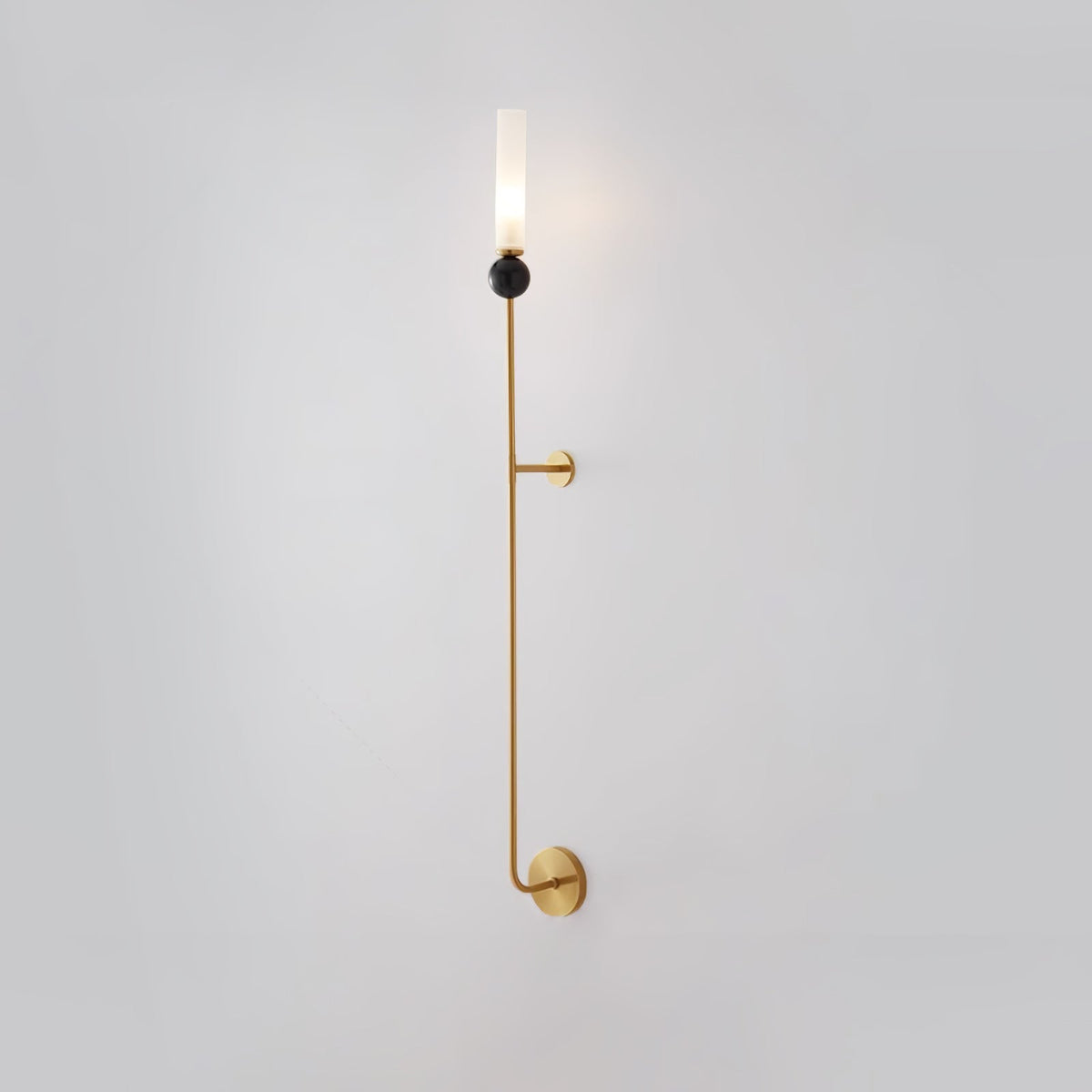 Seen from a slightly different angle, this tall Clérachic brass vertical wall light stands full length on plain grey.