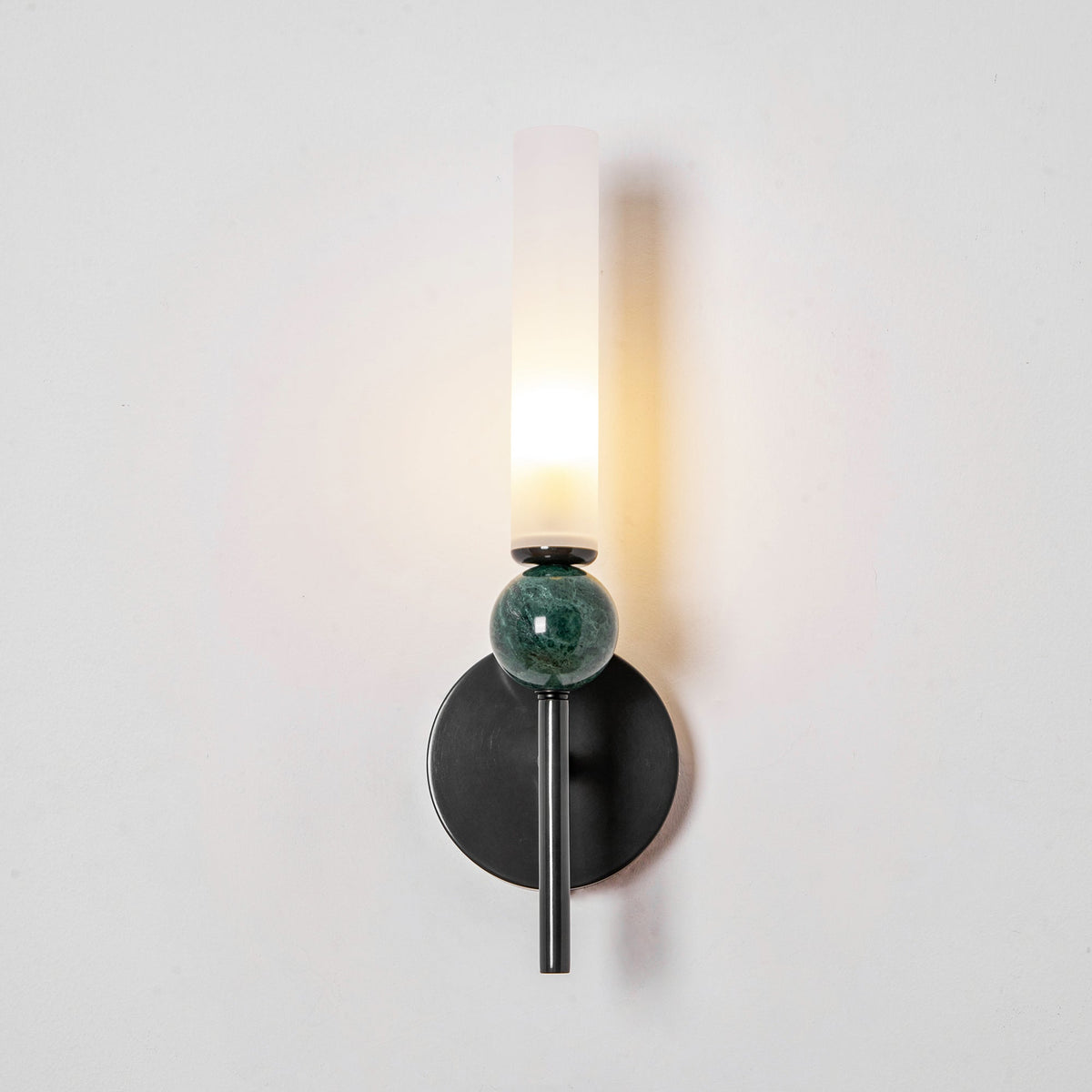 Lit at an angle against a white wall, the Clérachic wall light throws its shadow across the plaster behind it.