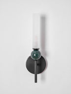 Straight-on and unlit, the frosted cylinder of the Clérachic wall light sits above its veined green marble sphere.