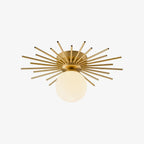 On a soft pink backdrop, the brass rods and globe of this Clérachic ceiling light spread wide.