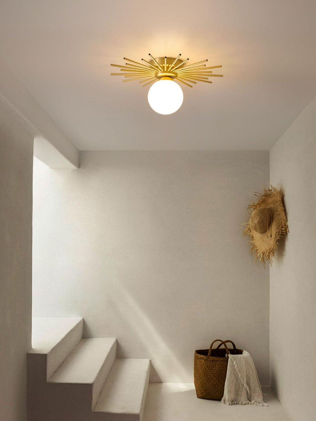 In a stairwell hung with woven wall art, this Clérachic ceiling light glows warm above a floor basket.