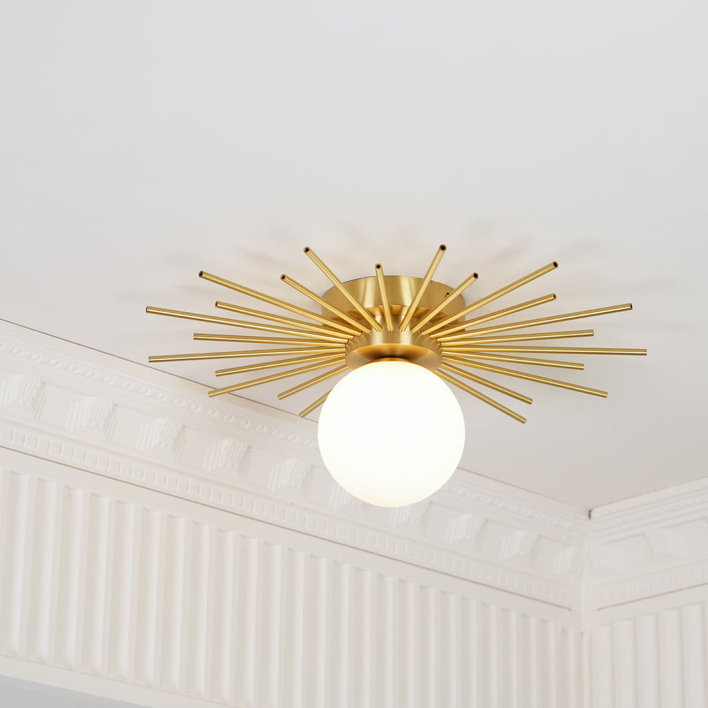 This Clérachic ceiling light sits near crown moulding, its brass rods and globe caught at a close angle.