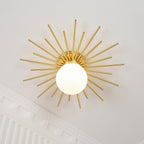 On a wall near ornate crown moulding, this Clérachic wall light shows its full sunburst of brass rods.