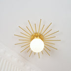Low angled view of this Clérachic ceiling light against a corner of ornate crown moulding, rays spread wide.