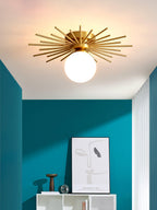 A framed print and bird sculpture sit on a white cabinet beneath this Clérachic ceiling light, against a teal wall.