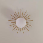 On a plain wall, this Clérachic wall light spreads its brass rays around a central frosted glass globe.
