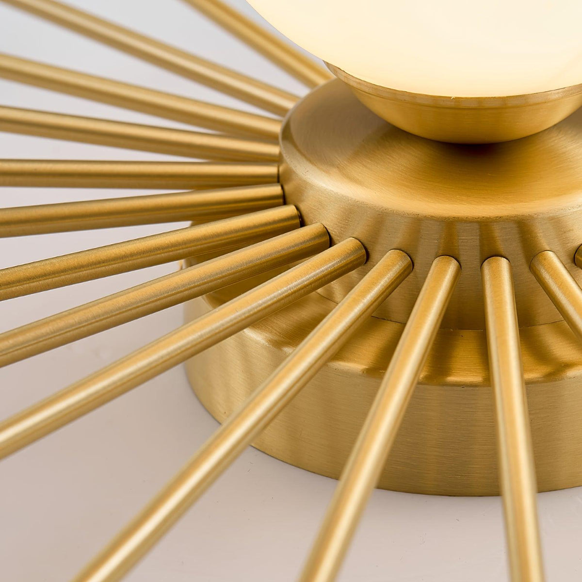 Close view of the brass rods radiating from the mounting disc of this Clérachic ceiling light.