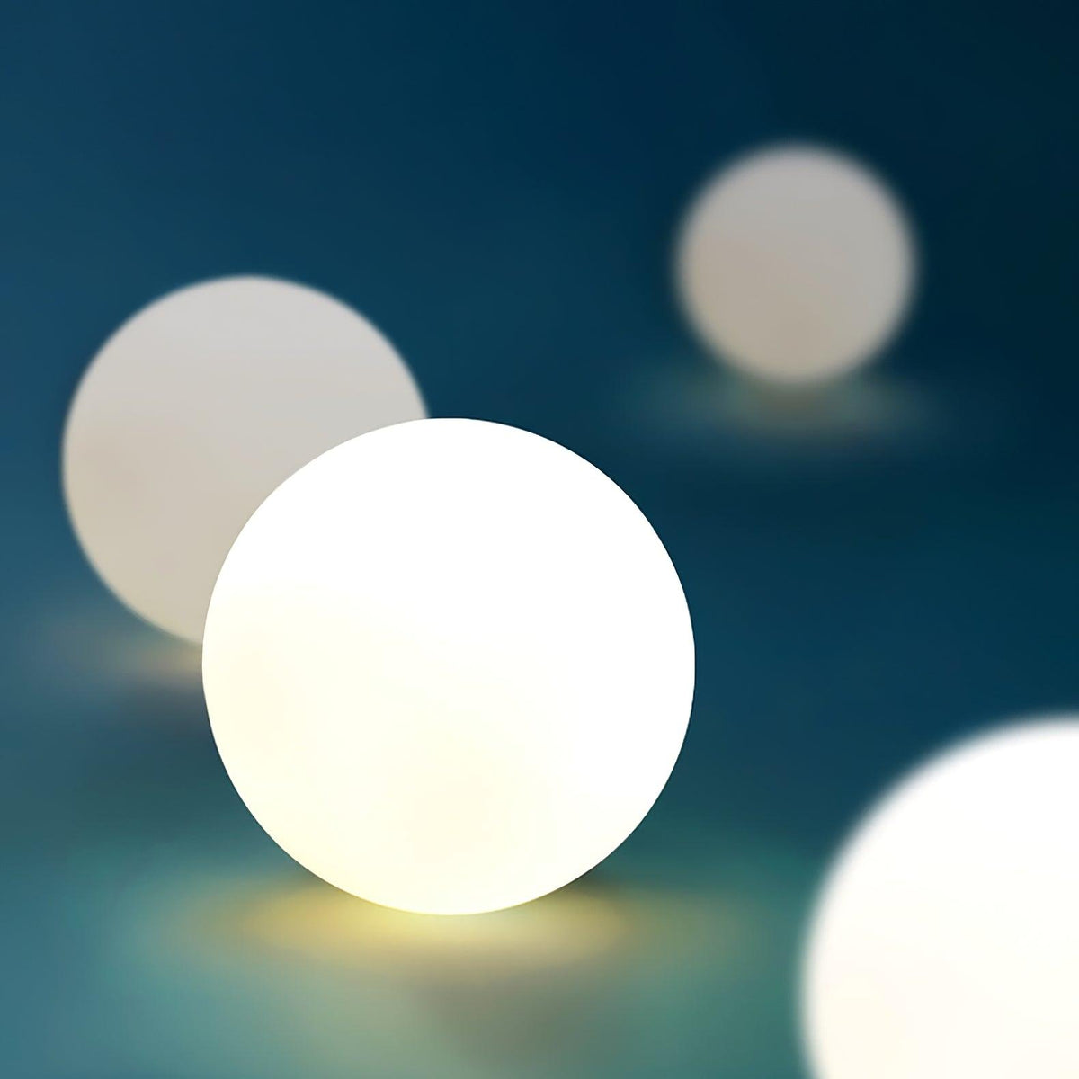 Blurred close view of the frosted globe on this Clérachic ceiling light, glowing softly against teal.