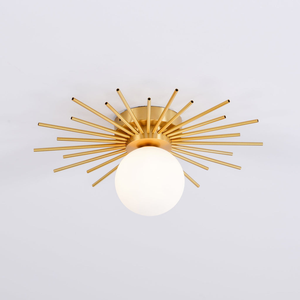 Front-on against plain grey, this Clérachic ceiling light shows the globe centred beneath its brass rays.