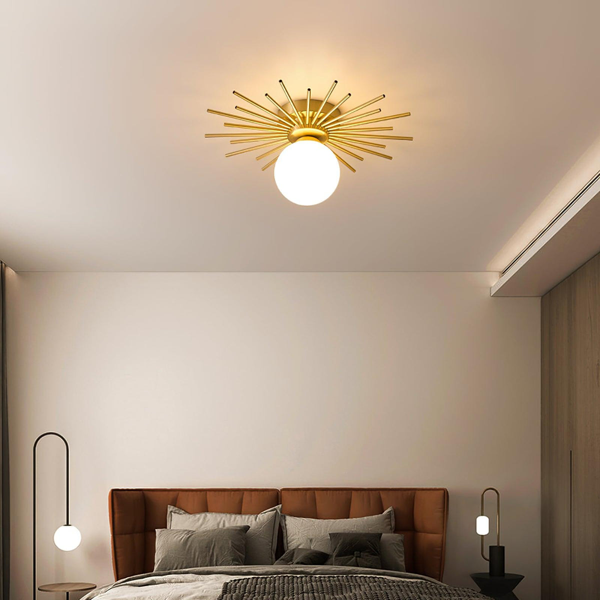 Lit warm above a bed with a rust suede headboard, this Clérachic ceiling light sits between two slim floor lamps.