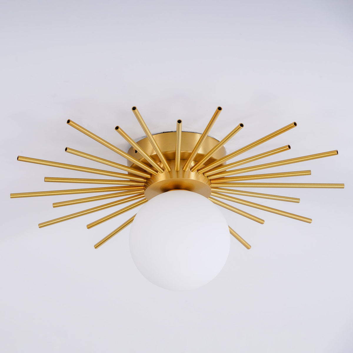 Close angled shot on grey of this Clérachic ceiling light, its brass spikes catching the studio light.