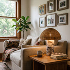 Clérachic's rattan table lamp lit on a wooden side table next to a beige sofa with a patterned throw.