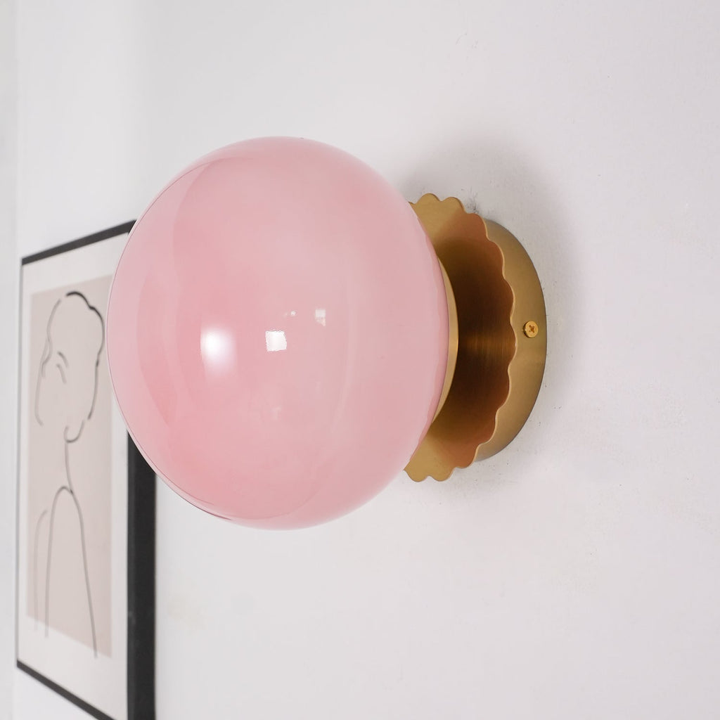 Rounded glass sconce mounted on a wall, glowing gently