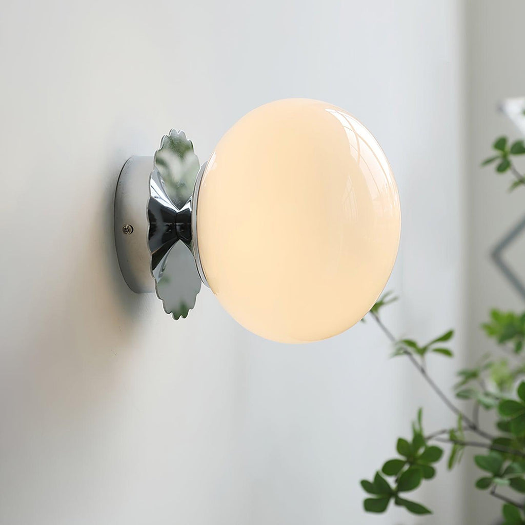 Glass-diffuser sconce casting warm light in a hallway