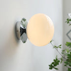 Glass-diffuser sconce casting warm light in a hallway