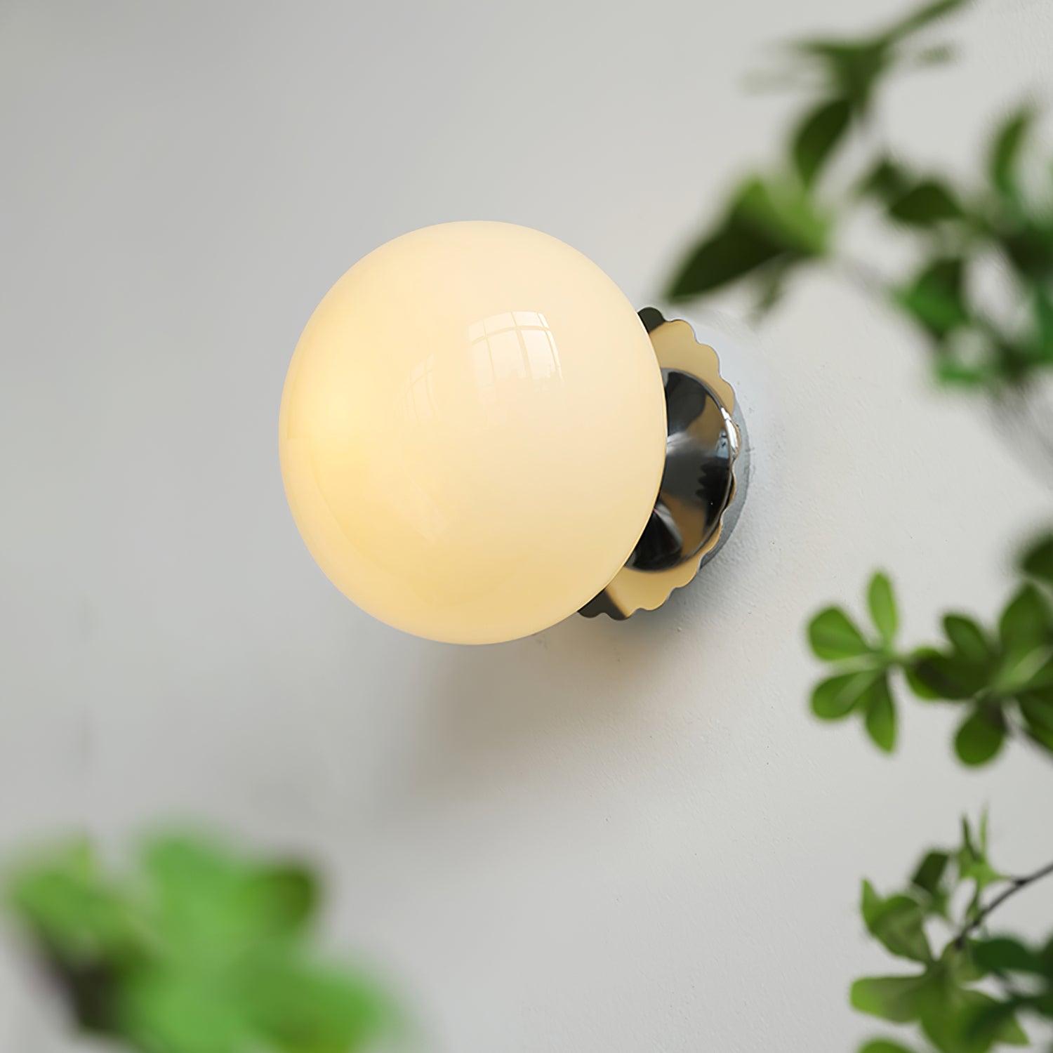 Marshmallow sconce with rounded glass shade on a wall