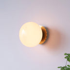 Tinted glass sconce glowing soft beside framed wall art