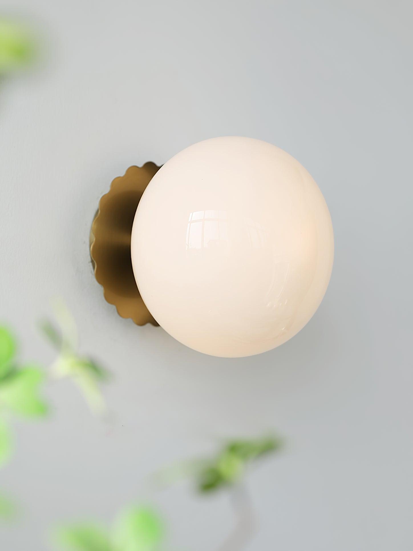 Glass-diffuser wall sconce casting a soft mood glow