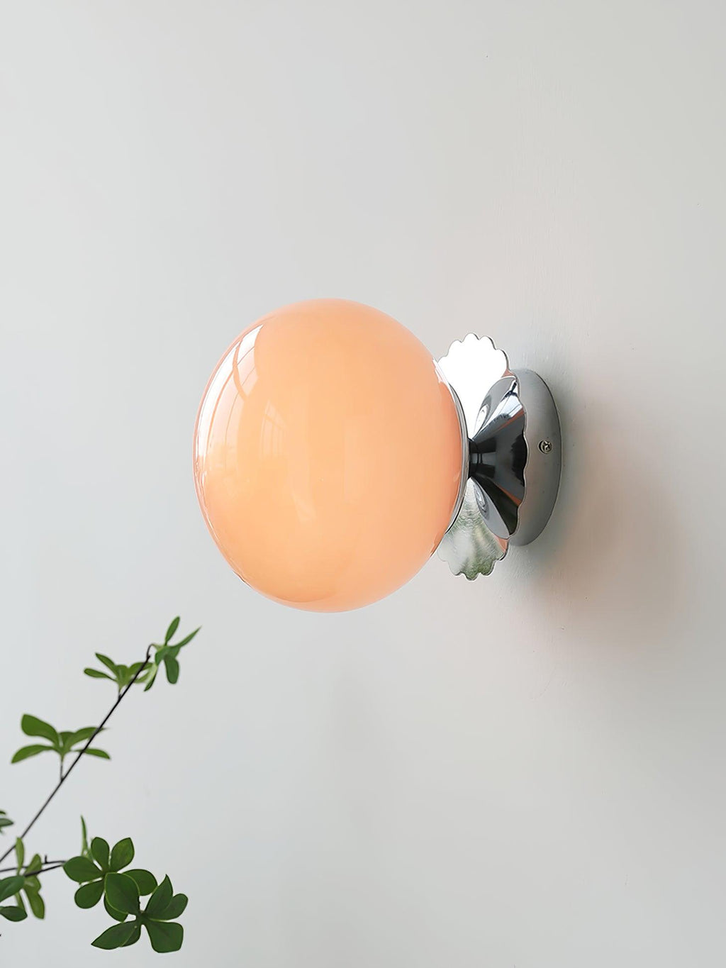 Marshmallow sconce with rounded glass shade beside shelving