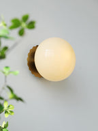 Wall sconce with soft glass diffuser and gold metal body