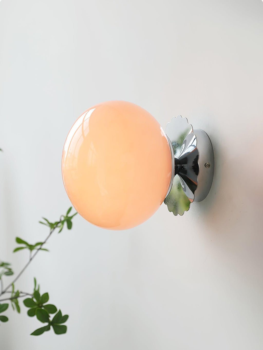 Tinted glass sconce casting gentle light in a styled room