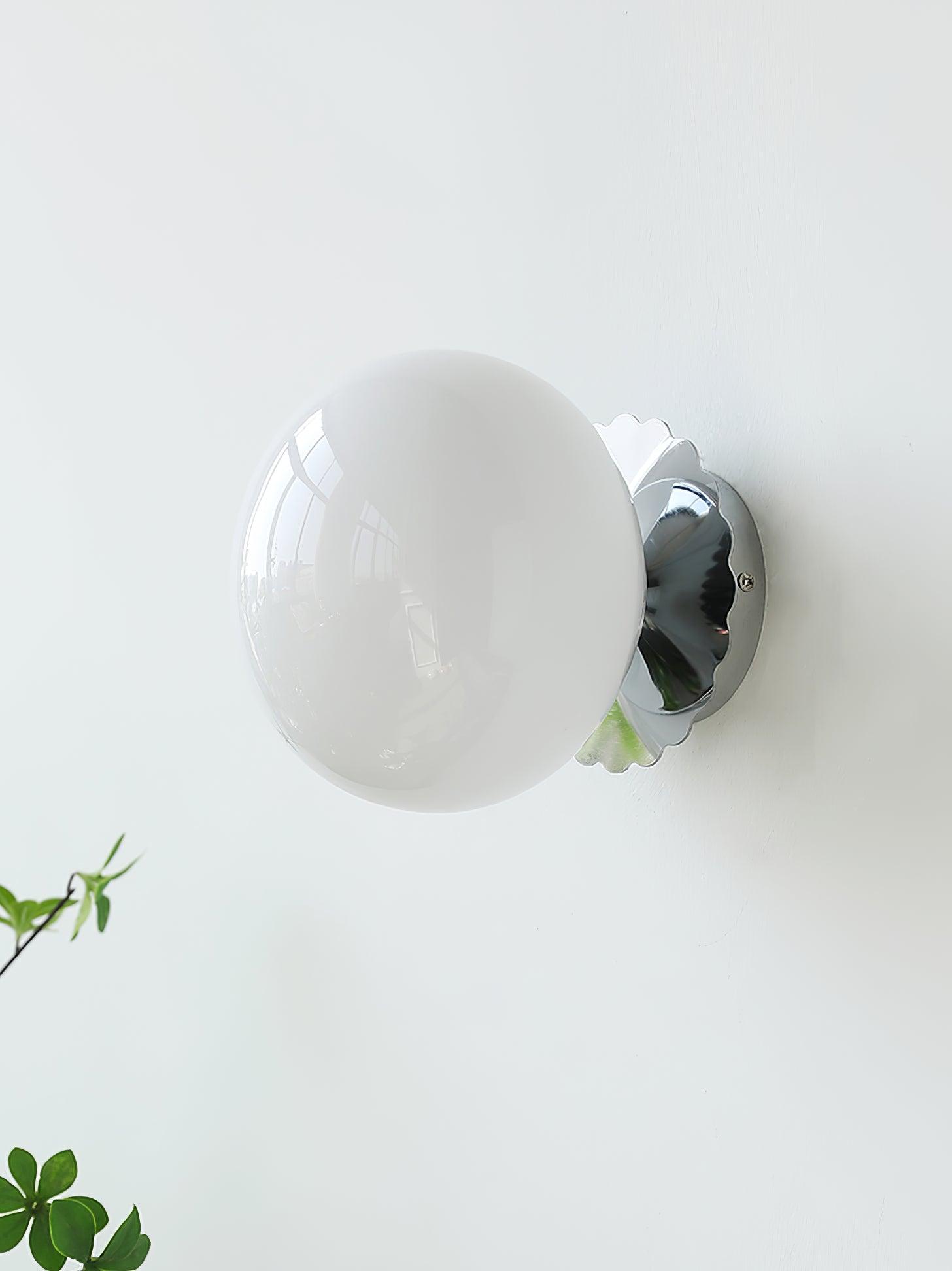 Glass-diffuser wall sconce with metal body glowing softly