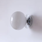 Marshmallow sconce casting a gentle glow in a styled room