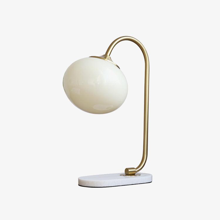Clérachic pastel glass table lamp with an off-white globe shade on a brass arm and oval marble base, shown unlit on a plain white backdrop.