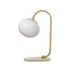 Clérachic pastel glass table lamp with a white globe shade on a gold arm and marble base, shown unlit on a plain white backdrop.