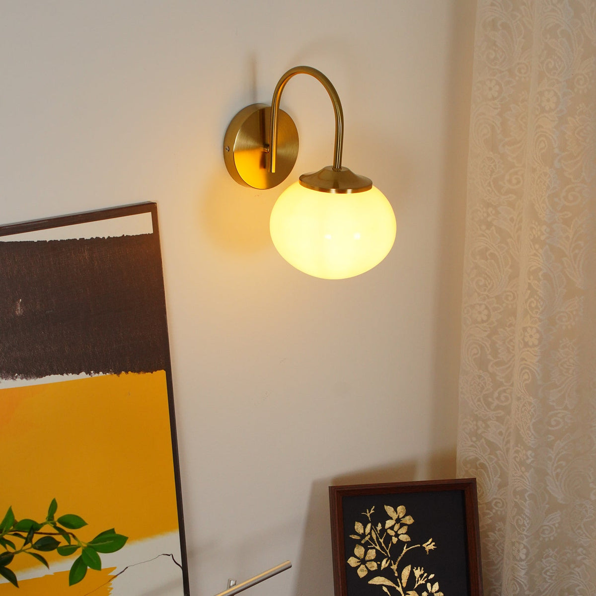 Mounted beside an abstract painting, this Clérachic wall light in copper and white glass glows warm.
