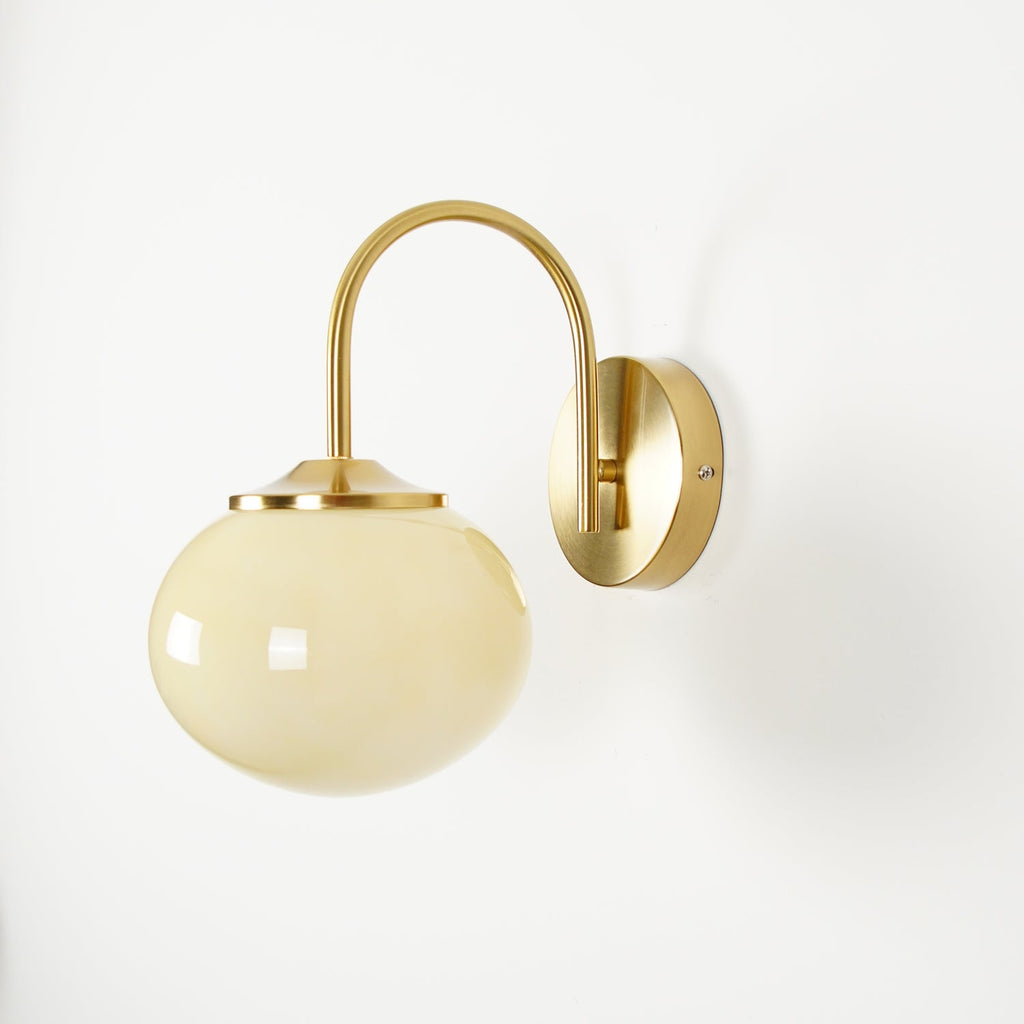 Straight-on view of this Clérachic wall light in copper and beige glass, unlit, on a white wall.
