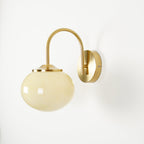 Straight-on view of this Clérachic wall light in copper and beige glass, unlit, on a white wall.