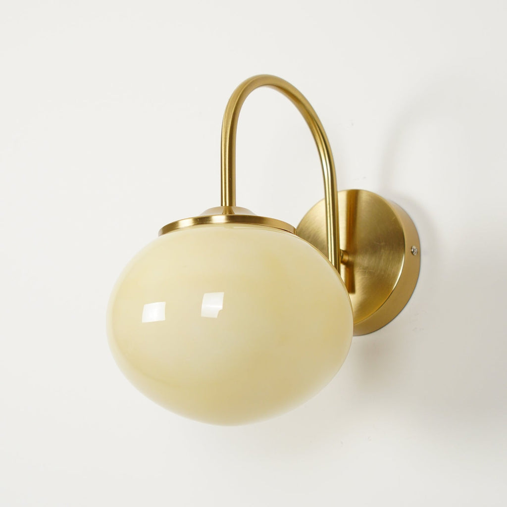 A slight angle shows this Clérachic wall light in copper and beige glass, unlit, on plain white.