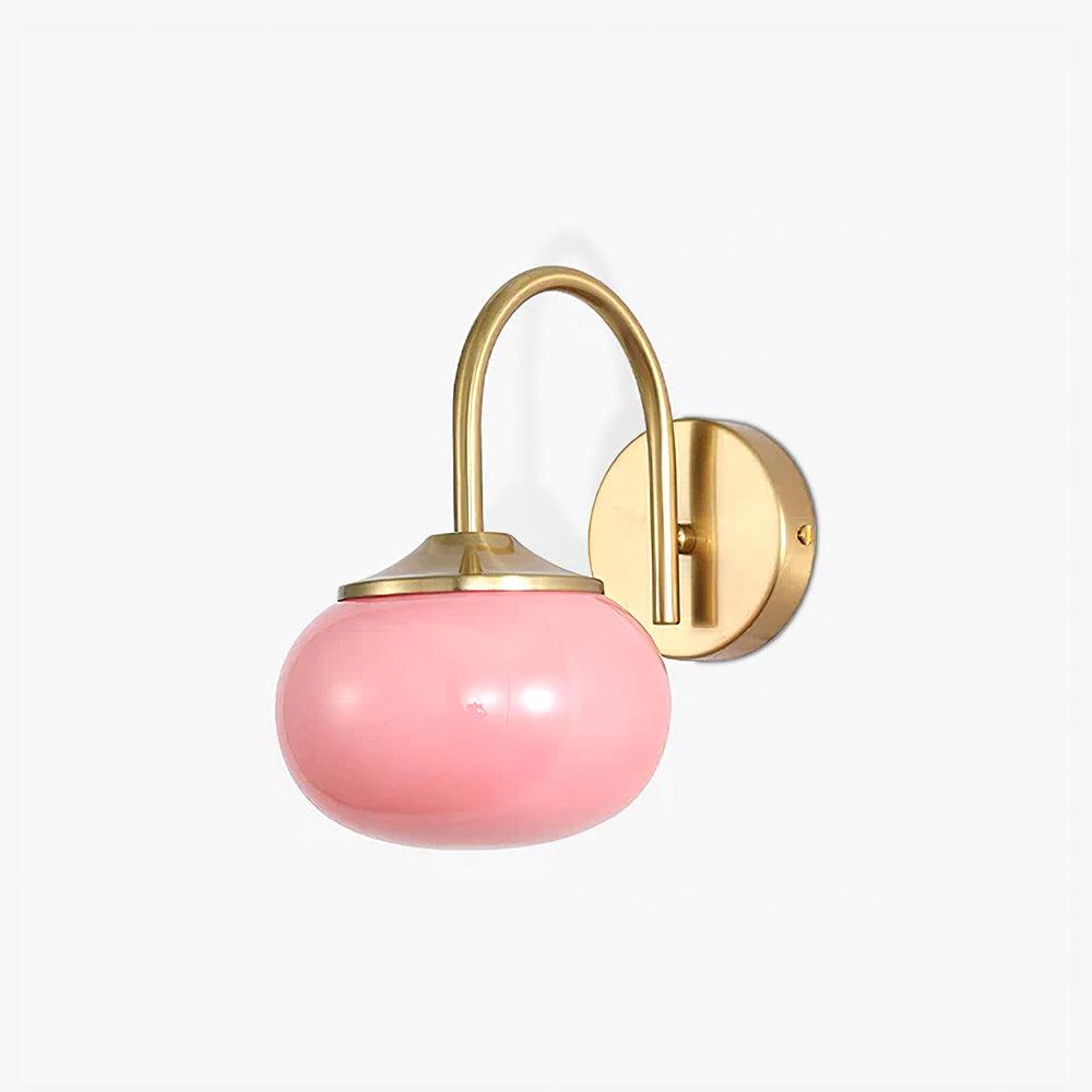 Close-up of the pink glass shade and copper arm on this Clérachic wall light, unlit, white background.